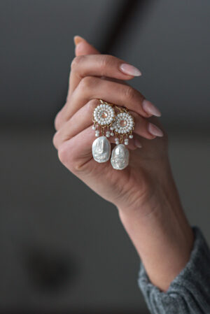 Model holding Milan an earring part of Kyla Jewelry's Bridal range.